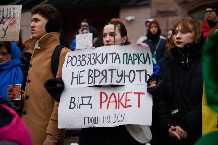 Photo for Ukrainian female holds a banner "New Parks Won't Save From Russian Rockets" on a demonstration. Kyiv - 10 February,2024 - Royalty Free Image
