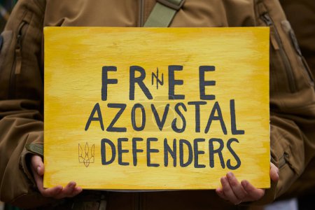 Foto de La persona sostiene una pancarta amarilla "Free Azovstal Defenders" en una manifestación pública. Kiev - 17 de marzo de 2024 - Imagen libre de derechos