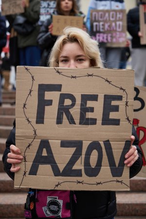 Foto de Joven mujer ucraniana posando con un cartel "Azov libre" en una manifestación por la liberación de los defensores capturados de Mariupol. Kiev - 17 de marzo de 2024 - Imagen libre de derechos