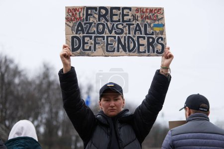 Foto de Persona ucraniana posando con un cartel "Free Azovstal Defenders" en una manifestación. Kiev - 24 de marzo de 2024 - Imagen libre de derechos