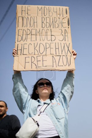 Foto de Mujer ucraniana posando con una pancarta "No te calles. La cautividad mata. Lucha por Invencible. Free Azov "en un mitin. Kiev - 31 de marzo de 2024 - Imagen libre de derechos