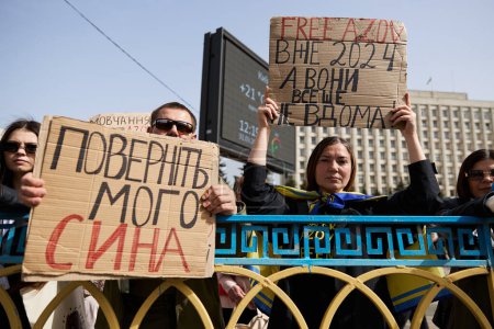 Photo for Ukrainian family demonstrating with banner "Free My Son" and " Free Azov" on a public rally. Kyiv - 31 March,2024 - Royalty Free Image
