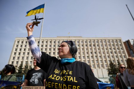Foto de La activista ucraniana Anna Kurtsanovskaya muestra un helicóptero como símbolo de los defensores de Mariupol en una manifestación pública. Kiev - 31 de marzo de 2024 - Imagen libre de derechos