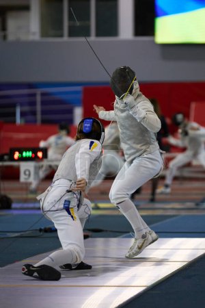 Photo for Two fencers fight on the fencing track at the National Fencing Championship of Ukraine. Kyiv - 30 March,2024 - Royalty Free Image
