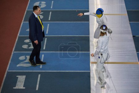 Photo for The judge watches the sword fight of the National Fencing Team Members on the track during the Championship of Ukraine. Kyiv - 30 March,2024 - Royalty Free Image