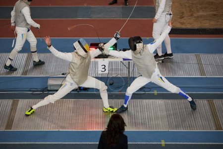 Photo for Two professional fencers fight on the track during National Fencing Championship of Ukraine. Kyiv - 30 March,2024 - Royalty Free Image