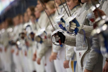 Photo for Ukrainian fencers raise swords in honor of the fallen defenders during the minute of silence at the opening ceremony of the National Fencing Championship of Ukraine. Kyiv - 30 March,2024 - Royalty Free Image