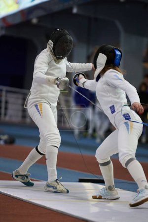 Photo for Couple of fencers fight with swords at the National Fencing Championship of Ukraine. Kyiv - 30 March,2024 - Royalty Free Image