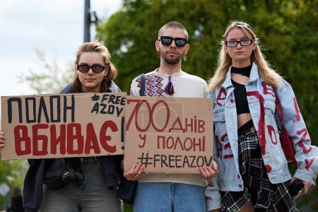 Photo for Young Ukrainian activists posing with banners "Free Azov" on a rally dedicated to captured Ukrainian soldiers who remain imprisoned in russia. Kyiv - 14 April,2024 - Royalty Free Image