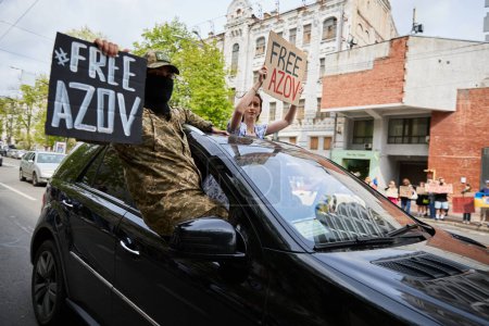 Photo for Ukrainian activists riding in a car with banners "Free Azov" in center of Kyiv - 14 April,2024 - Royalty Free Image