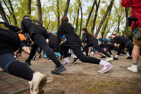 Grupo de mujeres estirándose y calentándose al comienzo de la carrera espartana. Kiev - 20 de abril de 2024