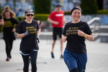 Foto de Alegres mujeres ucranianas corriendo la distancia en la competición Spartan Race en Kiev - 20 abril, 2024 - Imagen libre de derechos