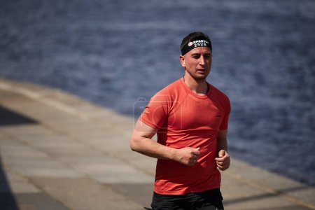 Foto de Apto chico ucraniano corriendo una distancia de sprint en la competición Spartan Race en Kiev - 20 abril, 2024 - Imagen libre de derechos
