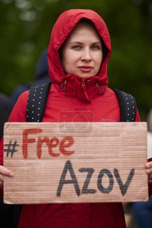 Foto de Joven ucraniana posando con una pancarta "Free Azov" en una manifestación pública en Kiev - 21 de abril de 2024 - Imagen libre de derechos