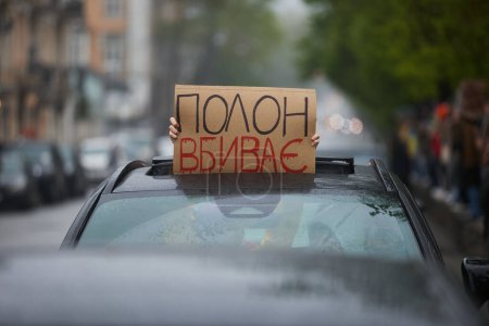 Foto de Activista muestra un letrero "Muerte en cautiverio" en idioma ucraniano en una manifestación pública. Kiev - 21 de abril de 2024 - Imagen libre de derechos