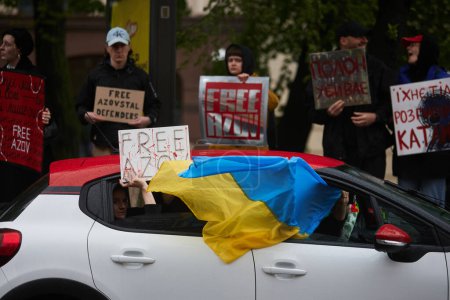 Photo for Ukrainian patriots riding in a car with national flag and sign "Free Azov" in Kyiv - 21 April,2024 - Royalty Free Image