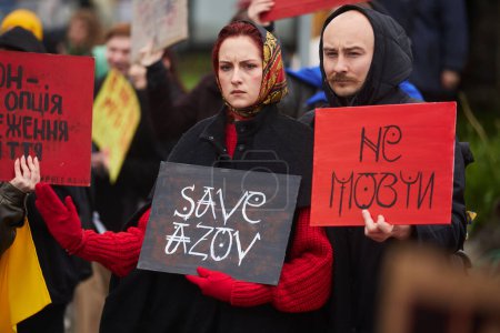 Foto de Pareja ucraniana posando con pancartas "Free Azov" y "Don 't Be Silent" en una manifestación en Kiev - 21 de abril de 2024 - Imagen libre de derechos