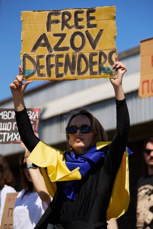 Foto de Joven ucraniana posando con un cartel "Free Azov Defenders" en una manifestación en Kiev - 28 de abril de 2024 - Imagen libre de derechos