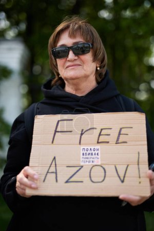 Photo for Senior Ukrainian lady demonstrating with a sign "Free Azov". Kyiv - 5 May,2024 - Royalty Free Image