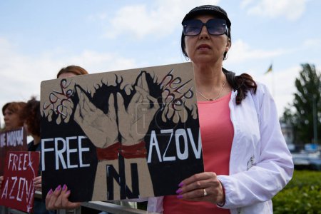 Photo for Ukrainian woman posing with a sign "Free Azov" on a public rally. Kyiv - 5 May,2024 - Royalty Free Image