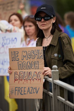 Foto de Mujer ucraniana posando con una pancarta "Free Azov" en las manos. Kiev - 5 de mayo de 2024 - Imagen libre de derechos