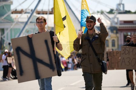 Téléchargez les photos : Jeunes patriotes ukrainiens marchant avec un logo de la brigade Azov sur une manifestation pacifique à Kiev - 19 Mai, 2024 - en image libre de droit