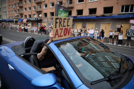 Foto de Activistas cabalgan en un cabrio con un cartel "Free Azov" en una manifestación pública en Kiev - 9 de junio de 2024 - Imagen libre de derechos