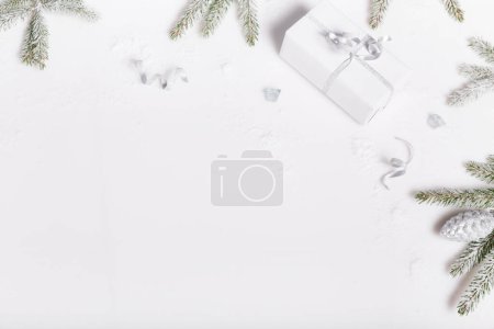 Foto de Cajas de regalo de Navidad y ramas de abeto cubiertas de nieve sobre un fondo blanco, vista superior, puesta plana. Feliz Navidad tarjeta de felicitación, marco. Feliz Año Nuevo. - Imagen libre de derechos