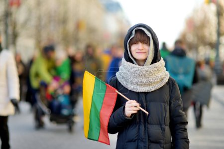 Foto de Adolescente divertida celebrando el Día de la Independencia de Lituania con bandera tricolor lituana en Vilna, Lituania - Imagen libre de derechos