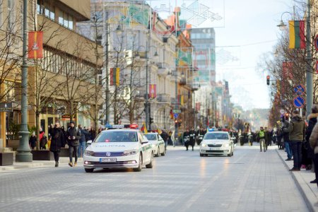 Téléchargez les photos : VILNIUS, LITUANIE - 11 MARS 2022 : Trois voitures de police conduisent un défilé festif alors que la Lituanie célèbre le 32e anniversaire de sa restauration de l'indépendance. - en image libre de droit