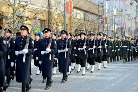 Foto de VILNIUS, LITUANIA - 11 de marzo de 2022: Desfile festivo mientras Lituania conmemora el 32º aniversario de su restauración de la independencia. Participantes del desfile llevando banderas nacionales. - Imagen libre de derechos