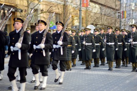 Foto de VILNIUS, LITUANIA - 11 de marzo de 2022: Desfile festivo mientras Lituania conmemora el 32º aniversario de su restauración de la independencia. Participantes del desfile llevando banderas nacionales. - Imagen libre de derechos