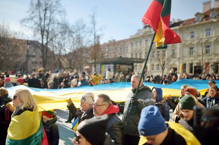Téléchargez les photos : VILNIUS, LITUANIE - 11 MARS 2022 : Des gens joyeux portant des drapeaux lituaniens tricolores lors d'événements festifs alors que la Lituanie célébrait le 32e anniversaire de sa restauration de l'indépendance. - en image libre de droit