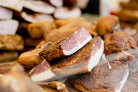 Foto de Selection of assorted home made meats, jerky and sausages on a farmers market in Vilnius, Lithuania. Kaziukas, traditional spring fair in capital of Lithuania. - Imagen libre de derechos