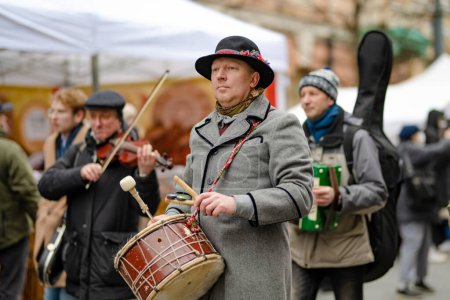 Téléchargez les photos : VILNIUS, LITHUANIA - MARCH 4, 2022: Cheerful people participating in humorous parade during Kaziuko muge or Kaziukas, traditional Easter market, crafts fair held every March on Old Town streets. - en image libre de droit