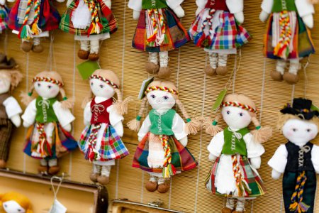 Foto de Cute handmade ragdoll dolls in Lithuanian national costumes sold on Easter market in Vilnius. Lithuanian capitals annual traditional crafts fair is held every March on Old Town streets. - Imagen libre de derechos