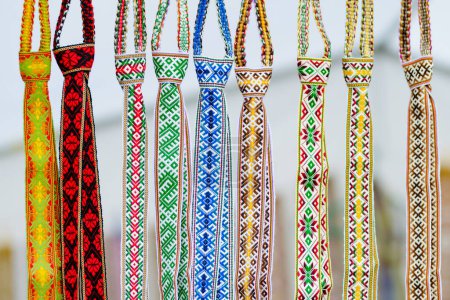 Foto de Detalles de un tejido lituano colorido tradicional. Cinturones tejidos como parte del traje nacional lituano que se vende en la tradicional feria de Pascua en Vilna, Lituania - Imagen libre de derechos