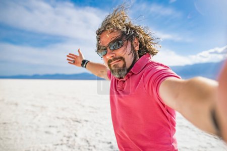 Photo for Young male hiker exploring salt crust in Badwater Basin, the lowest point in north America, Death Valley, California, USA. Exploring the American Southwest. - Royalty Free Image