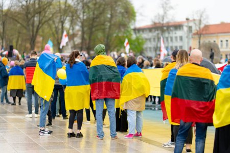 Foto de VILNIUS, LITUANIA - 2 de marzo de 2022: Manifestación pacífica contra la guerra y la invasión rusa en Ucrania. El pueblo de Lituania se une en apoyo de Ucrania con banderas de Ucrania y Lituania. - Imagen libre de derechos