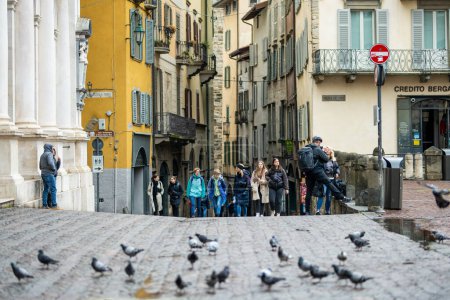 Téléchargez les photos : BERGAMO, ITALIE - AVRIL 2022 : Rue médiévale étroite de la ville de Bergame au nord-est de Milan. Vue panoramique sur Citta Alta, le quartier supérieur de la ville, entouré de murs vénitiens. Bergame, Lombardie, Italie. - en image libre de droit