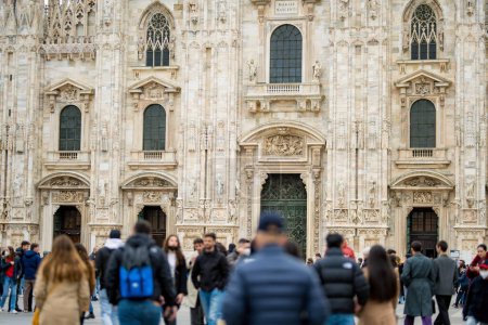Téléchargez les photos : MILAN, ITALIE - AVRIL 2022 : Détail du mur de la cathédrale de Milan (ou Duomo) avec un groupe de personnes brouillées sur la place de la cathédrale ou Piazza del Duomo dans le centre de Milan, Lombardie, Italie. - en image libre de droit
