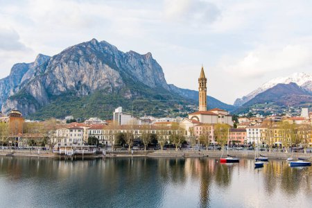 Cloudy aerial cityscape of Lecco town on spring evening. Picturesque waterfront of Lecco town located between famous Lake Como and scenic Bergamo Alps mountains. Vacation destination in Italy.