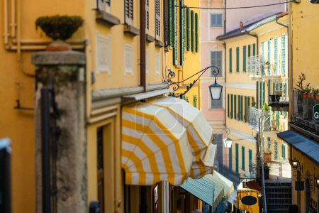Photo for Narrow street full of shops and restaurants in Bellagio, one of the most picturesque towns on the shore of Lake Como. Charming location with typical Italian atmosphere. Bellagio, Lombardy, Italy. - Royalty Free Image