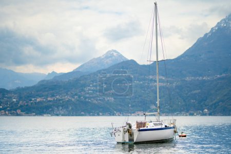 Foto de Pequeño yate atracado en el puerto deportivo de Varenna, una de las ciudades más pintorescas en la orilla del lago de Como. Varenna, Lombardía, Italia. - Imagen libre de derechos