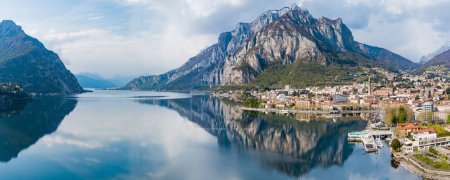 Photo for Sunny aerial cityscape of Lecco town on spring day. Picturesque waterfront of Lecco town located between famous Lake Como and scenic Bergamo Alps mountains. Vacation destination in Italy. - Royalty Free Image