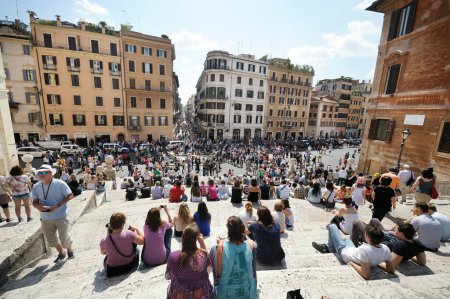 Foto de ROMA - MAYO 2011: Multitud sentada en la Plaza de España, los escalones exteriores más largos y anchos de Europa en el centro de Roma, Lazio, Italia. - Imagen libre de derechos