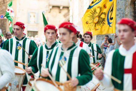 Photo for SIENA, ITALY - JULY 2013: Members of the noble Contrada dell'Oca carrying flags with a crowned goose on the Corteo Storico, a historical costume parade in Siena, Tuscany, Italy. - Royalty Free Image