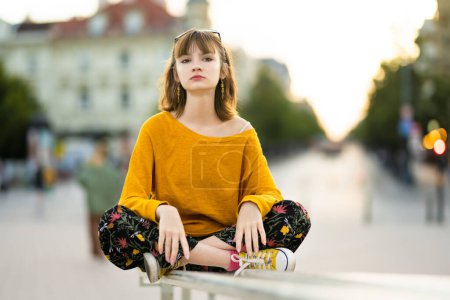 Téléchargez les photos : Adolescente mignonne portant un pull jaune explorant à Vilnius, en Lituanie, par une journée d'été chaude et ensoleillée. Loisirs en famille avec enfants. - en image libre de droit