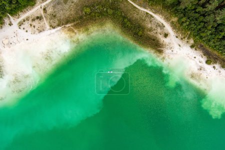 Photo for Aerial top down view of beautiful green waters of lake Gela. Birds eye view of scenic emerald lake surrounded by pine forests. Clouds reflecting in Gela lake, near Vilnius city, Lithuania. - Royalty Free Image