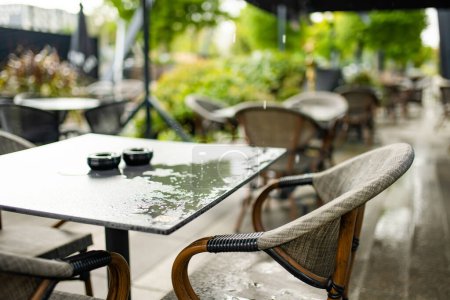 Foto de Mesa de café al aire libre en Vilna, Lituania, en el día lluvioso de verano. Agua goteando en la mesa del restaurante. Comer al aire libre. - Imagen libre de derechos